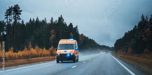 Wallpaper Mural Defocused photo of ambulance car on the highway, blurred image of an emergency car running on the forest road at the cloudy evening Torontodigital.ca