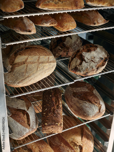 Baked fresh goods stoked on metallic racks at bakery shop photo