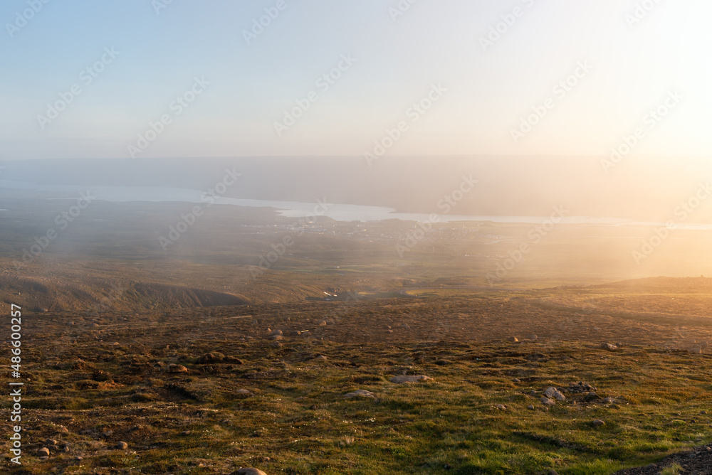 Panoramic view of a broad valley with a lake covered with fog as seen from the top of a mountain at sunset. Egilsstadir, Iceland. Panoramic view of a broad valley with a lake covered with fog as seen from the top of a mountain at sunset. Egilsstadir, Iceland.