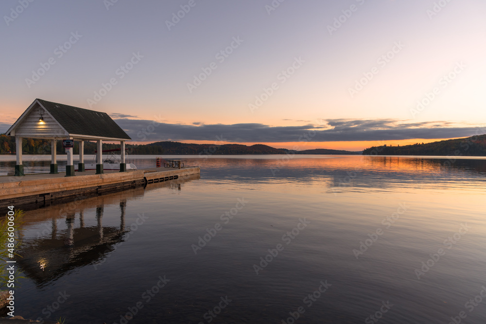 Beautiful lake with a wooden pier with a hut on it at dusk in autumn. Tranquil scene Beautiful lake with a wooden pier with a hut on it at dusk in autumn. Tranquil scene