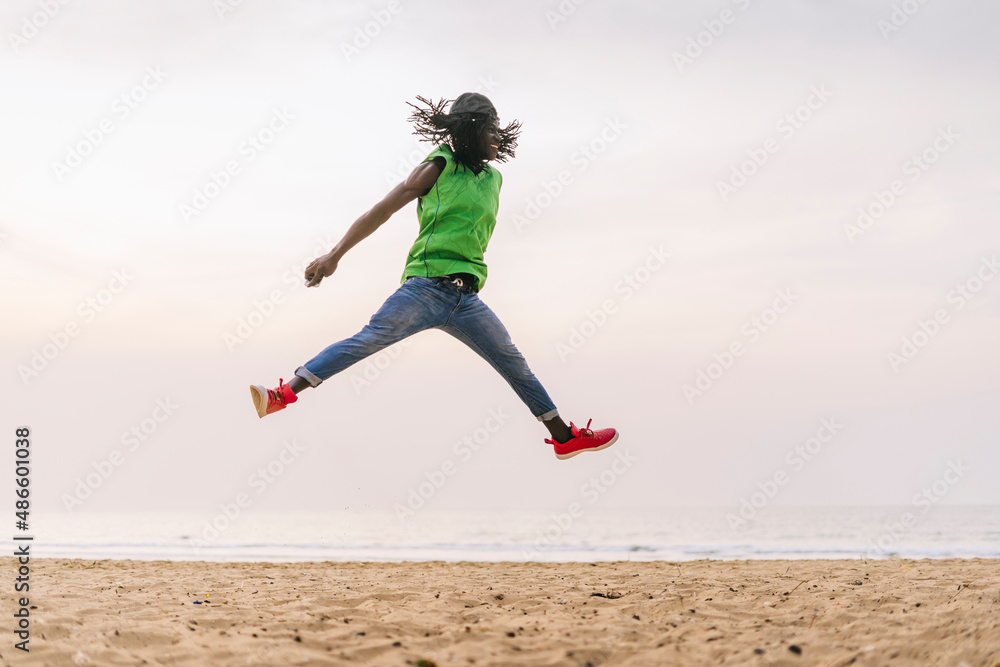Cool man jumping on seashore in sunset Cool man jumping on seashore in sunset