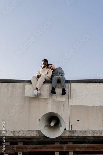 Friends climbin a wall helping each other photo