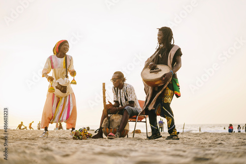 African men playing instruments near sea photo