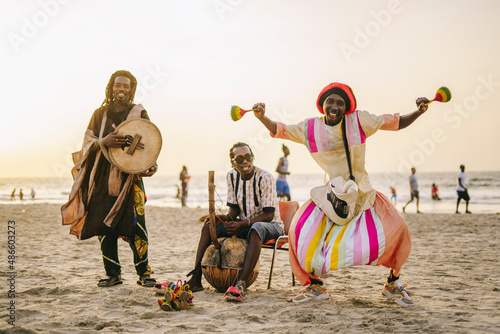 Traditional African group playing music on shore photo