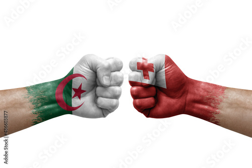Two hands punch to each others on white background. Country flags painted fists, conflict crisis concept between algeria and tonga