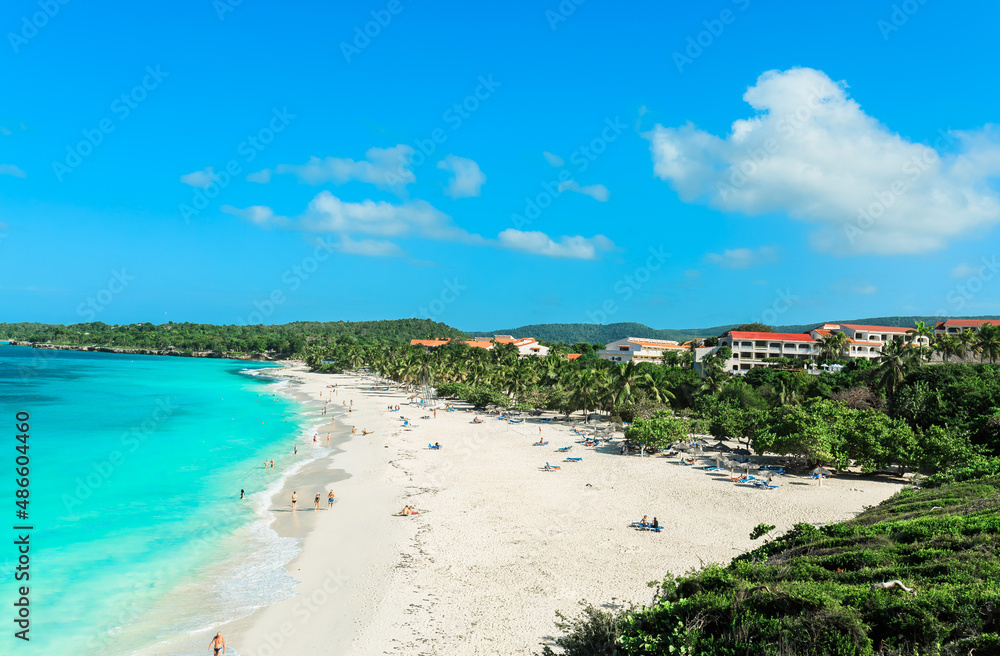 Holguin Province, Cuba, Esmeralda majestic wide open stunning inviting beach with people swimming, relaxing and enjoying their time on sunny beautiful day in turquoise ocean water, sunny day 