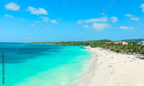 Holguin Province, Cuba, Esmeralda majestic wide open stunning inviting beach with people swimming, relaxing and enjoying their time on sunny beautiful day in turquoise ocean water, sunny day 