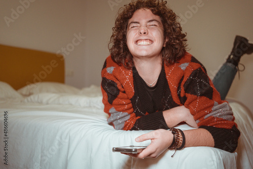 Happy woman checking phone on the bed