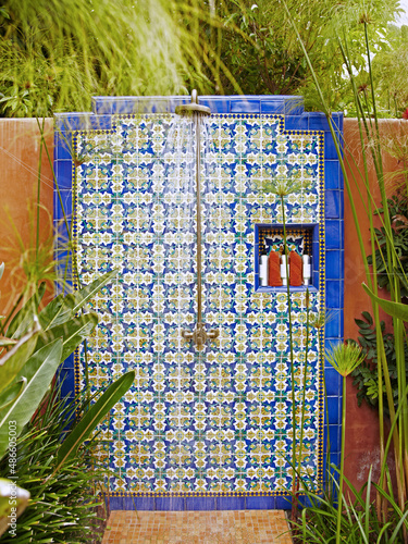 Outdoor tile shower with lush tropical plants at spa. photo