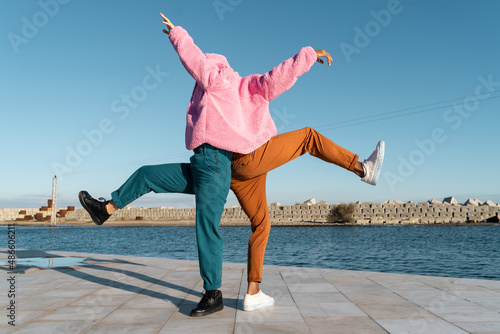 Friends sharing colorful jacket while dancing  photo