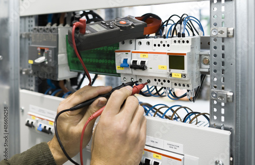electrician measuring voltage with a digital multimeter