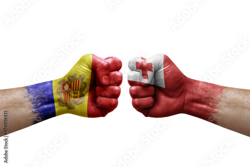 Two hands punch to each others on white background. Country flags painted fists, conflict crisis concept between andorra and tonga