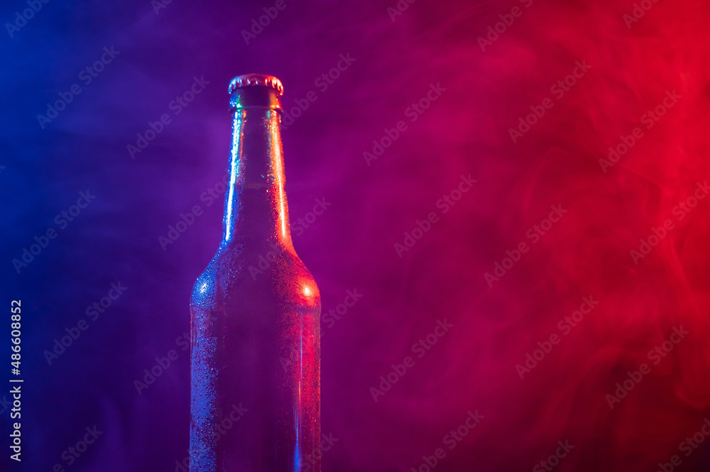 Glass bottle of beer in blue pink mist Glass bottle of beer in blue pink mist