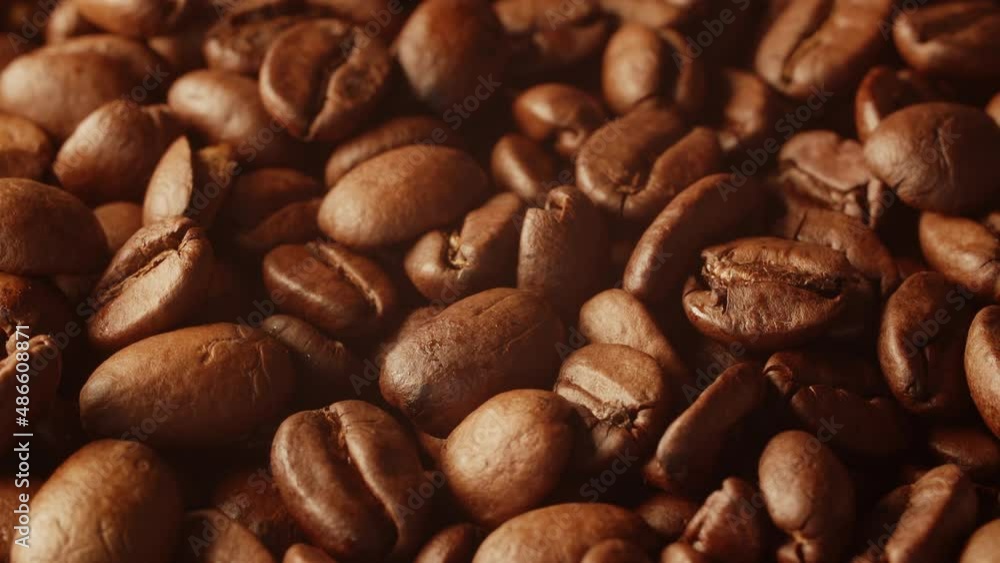 Macro-shot of vibrating and slowly moving coffe beans in warm light. Macro-shot of vibrating and slowly moving coffe beans in warm light.