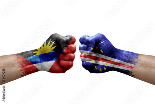Two hands punch to each others on white background. Country flags painted fists, conflict crisis concept between antigua and barbuda and cape verde