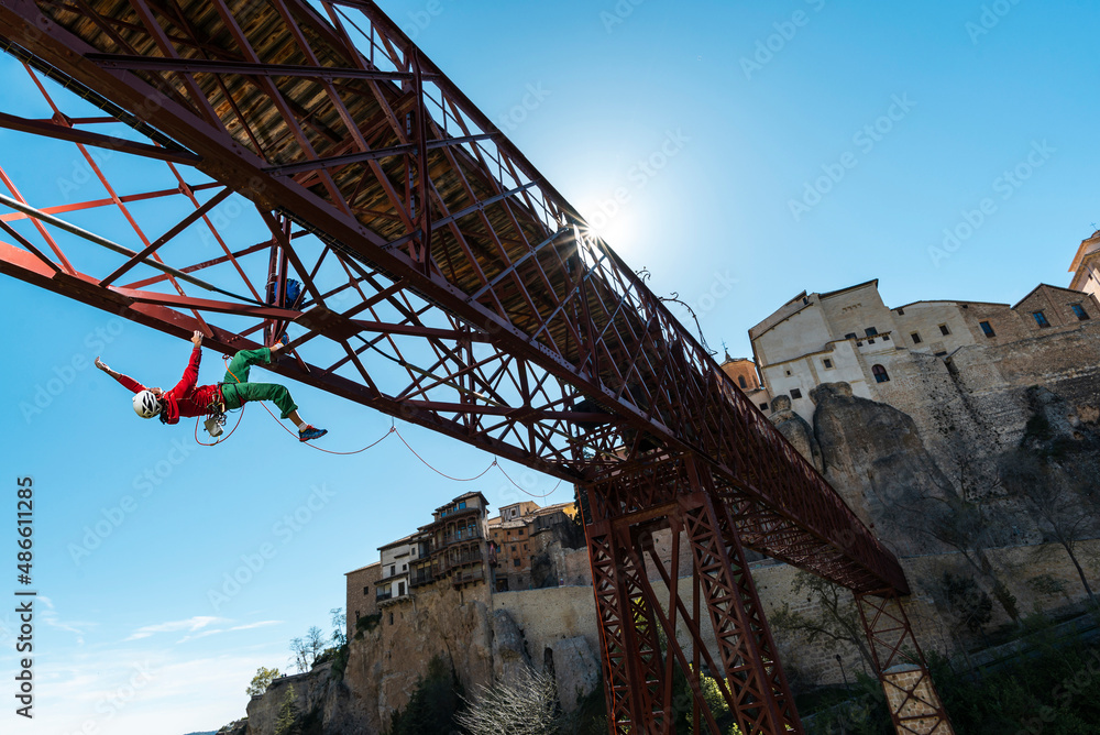 Authentic man rock climbing a metal bridge in the city Authentic man rock climbing a metal bridge in the city