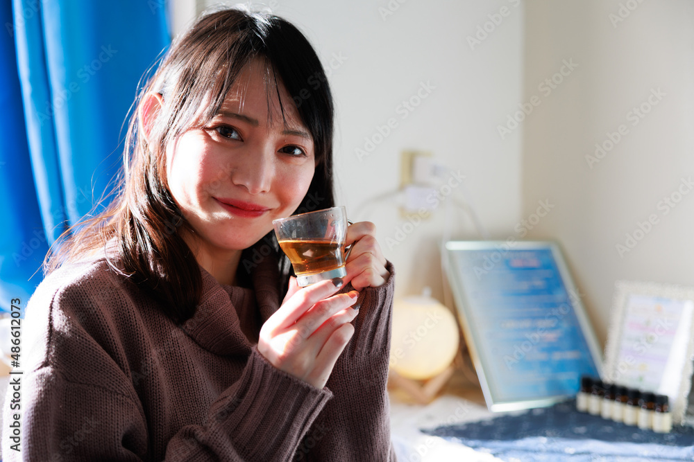 ガラスのコップに入ったお茶を飲むアジア人女性 ガラスのコップに入ったお茶を飲むアジア人女性