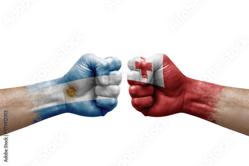 Two hands punch to each others on white background. Country flags painted fists, conflict crisis concept between argentina and tonga