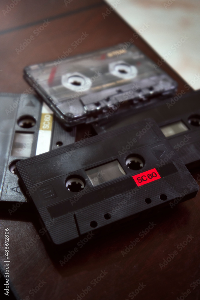 Fototapeta premium cintas de casete viejas reposan sobre una mesa de madera oscura esperando a ser usadas