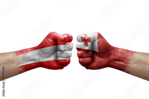 Two hands punch to each others on white background. Country flags painted fists, conflict crisis concept between austria and tonga