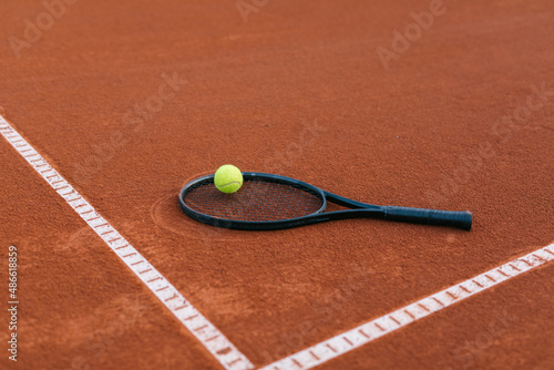 Tennis racquet on a court with tennis ball photo