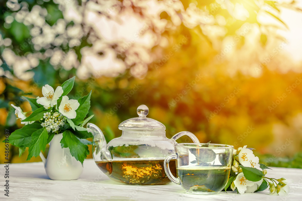 Philadelphus or garden jasmine flowers, healthy herbal tea cup of hot tea. Romantic dinner with therapeutic fragrant tea. Philadelphus or garden jasmine flowers, healthy herbal tea cup of hot tea. Romantic dinner with therapeutic fragrant tea.