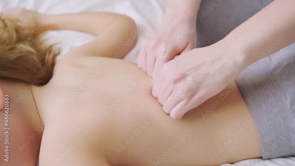 a mother massages her young daughter. courses of masseurs. a mother massages her young daughter. courses of masseurs.