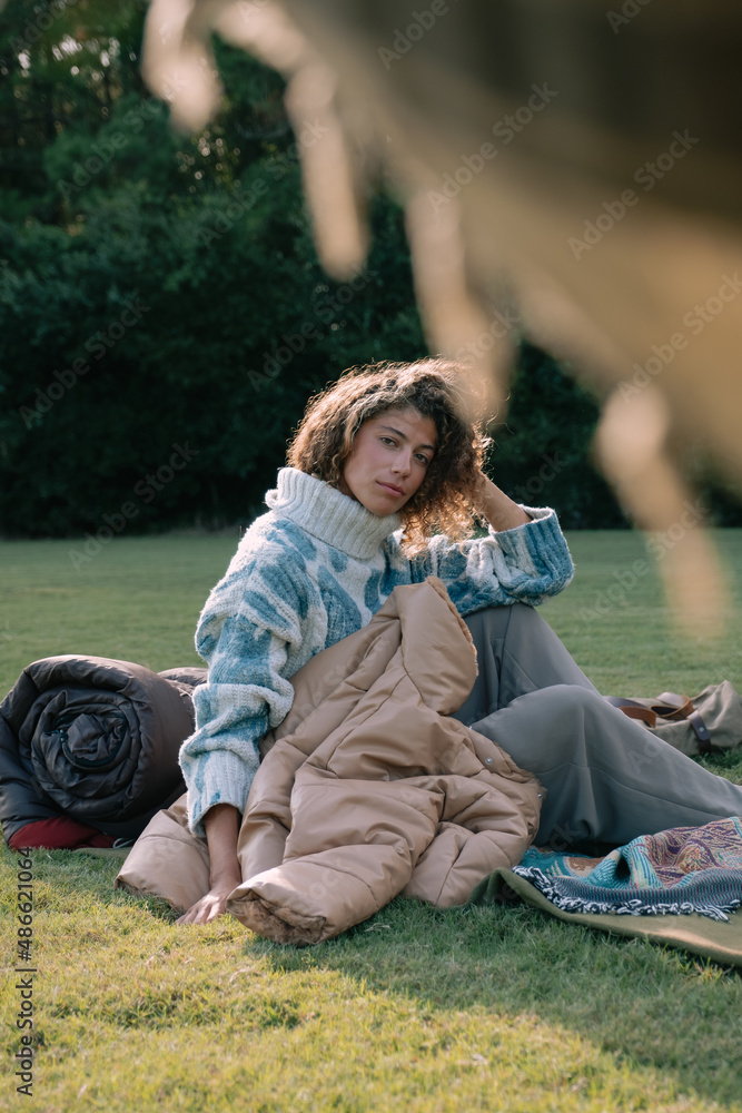 Young woman bundled up sitting outdoors. Young woman bundled up sitting outdoors.