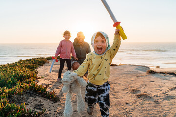 Happy family playing outdoors at sunset 