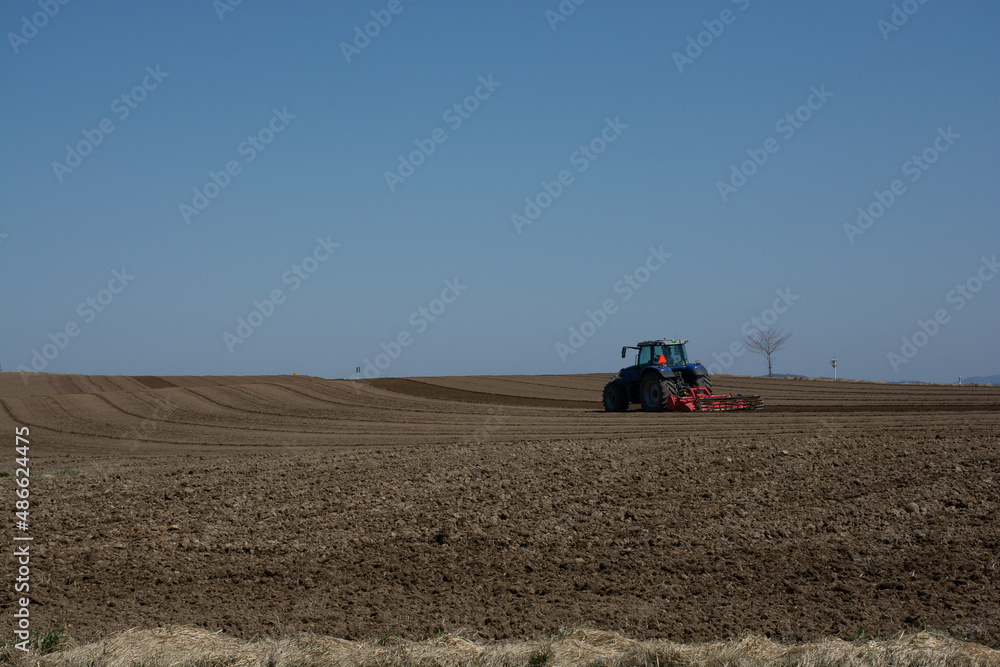 Obraz premium 春の畑の農作業 