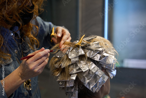 Woman with hair foils applied for colouring hairs photo