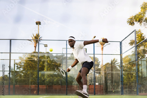 Black man playing with a racket in a tennis match