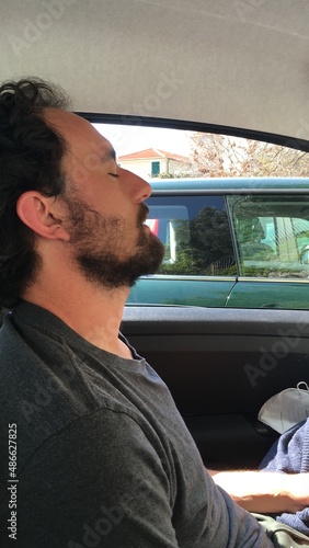 UGC man with a beard taking a nap in the car photo