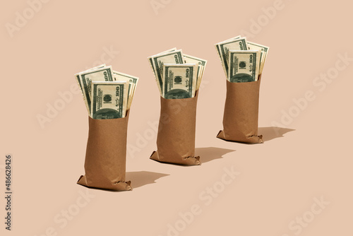 fake dollar bills in three paper bags