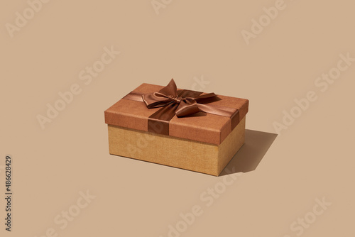 brown gift box tied with a brown satin ribbon