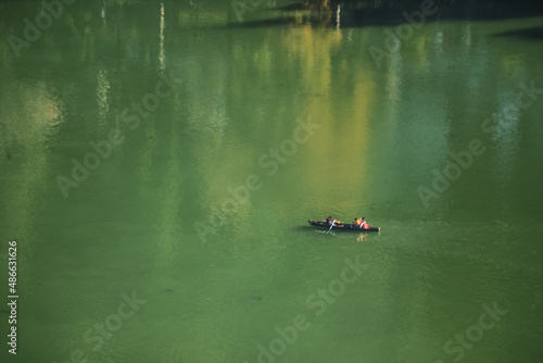 A boatman rowing a boat across the Nainital Lake in the morning 
