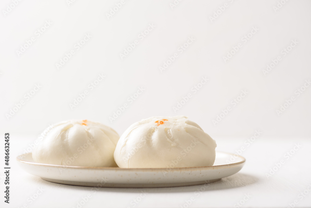 Fototapeta premium Steamed Chinese bun on white background, a popular Asian street food