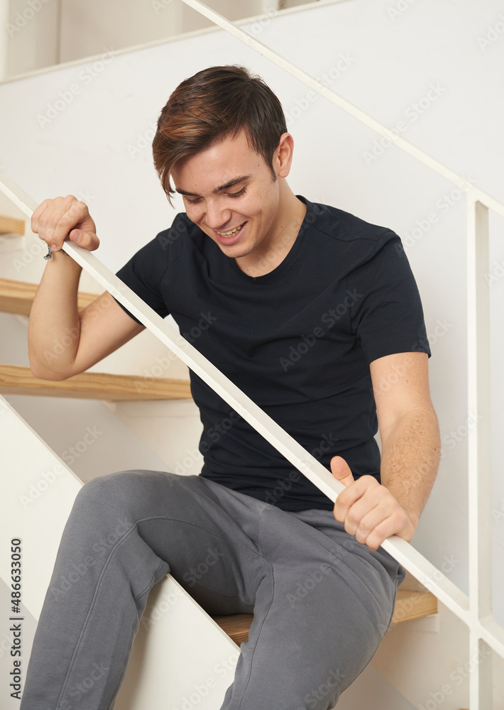 Young men at the staircase of his loft laughing Young men at the staircase of his loft laughing
