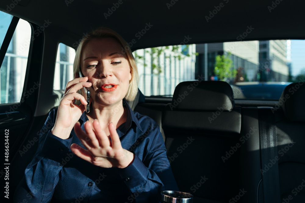 Middle-aged woman in car with phone. Middle-aged woman in car with phone.