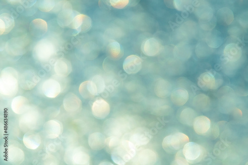 bright glitter background: bokeh effect from many colored lights on frozen glass, toning