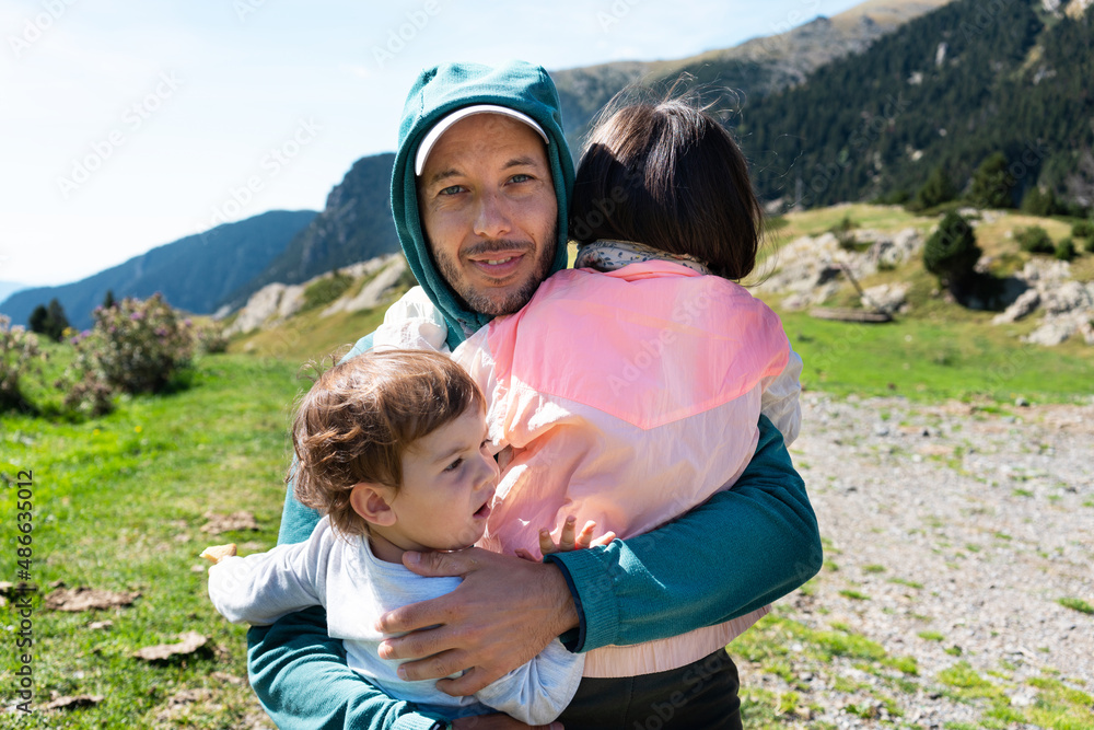 Father hugging daughters outdoors Father hugging daughters outdoors