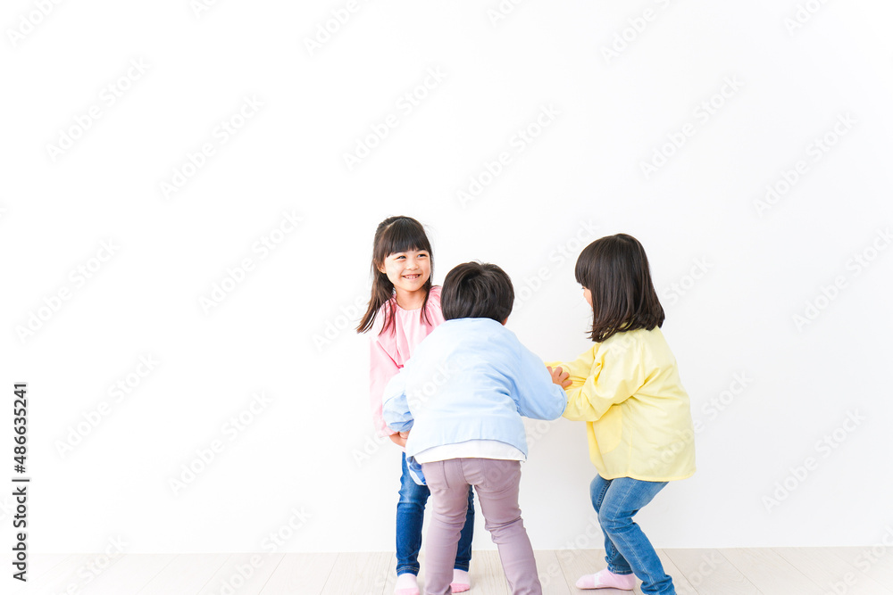 壁に並ぶ3人の幼稚園児 壁に並ぶ3人の幼稚園児