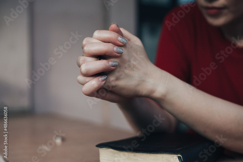 Asian woman praying while holding bible and believe in God.