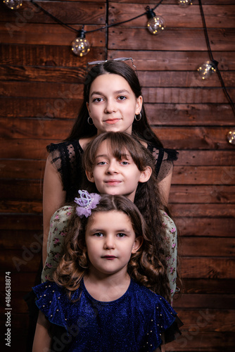 Portrait of three children girls located next to each other. Geometric pictures with people.