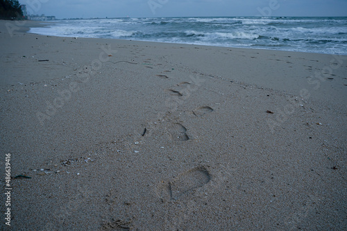 Set of footprints on the sand on a beach at dawn. Selective focus points