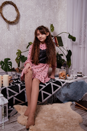 A cute little girl sits at home in a room on pallets. Breakfast.