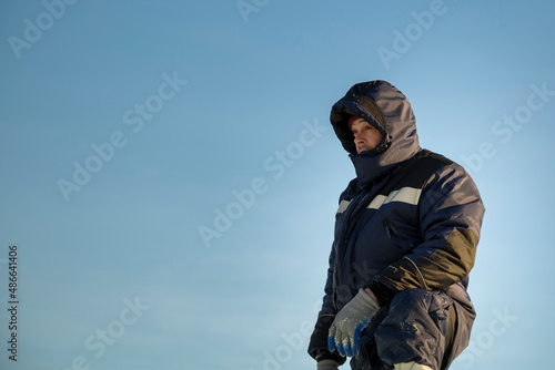 Portrait of a fitter in a blue jacket against the sky