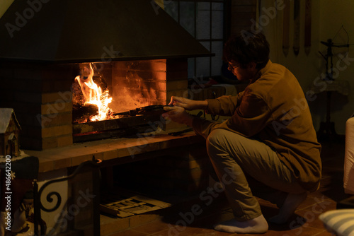 portrait of Man lighting the fireplace at home photo