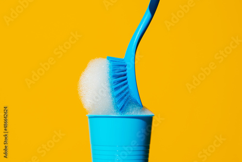 dishwashing brush with soap in a plastic cup