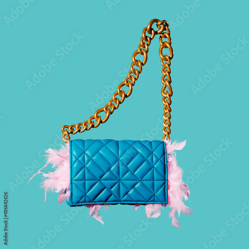 feather boa peeking out from a blue purse photo